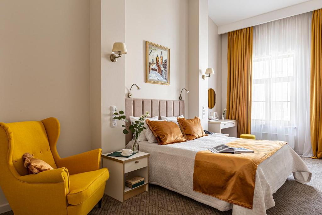 a bedroom with a bed and a yellow chair at Bohema in Saint Petersburg
