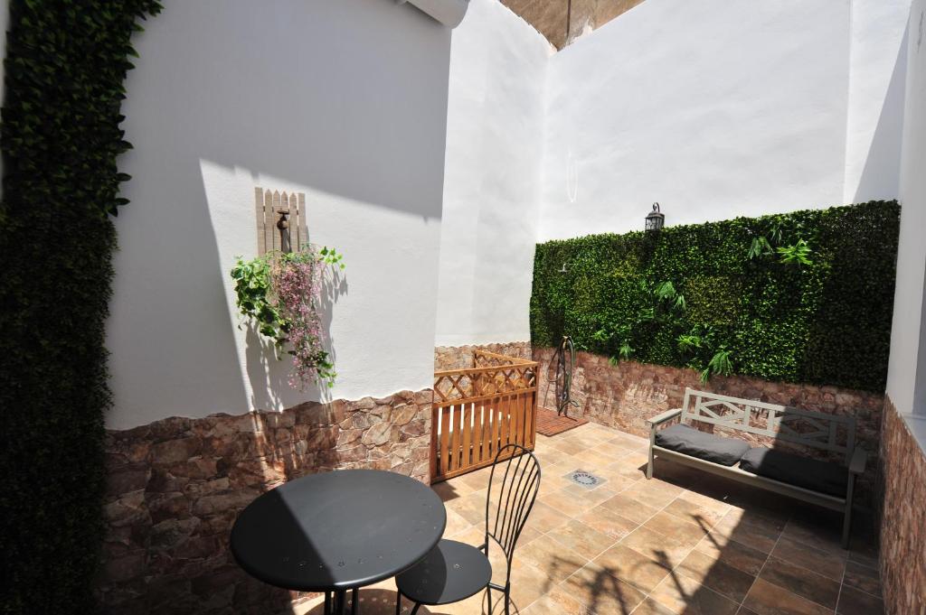 un patio con una mesa negra y un banco en Original Céntrico Bohemio, en Jerez de la Frontera