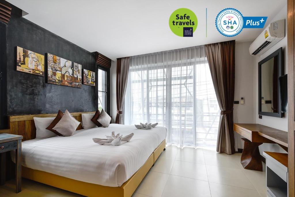 - une chambre avec un grand lit et une grande fenêtre dans l'établissement Casa Bella Phuket, à Chalong