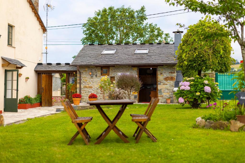 a table and two chairs in front of a house at Vivienda Vacacional Casa Fidel in Campas