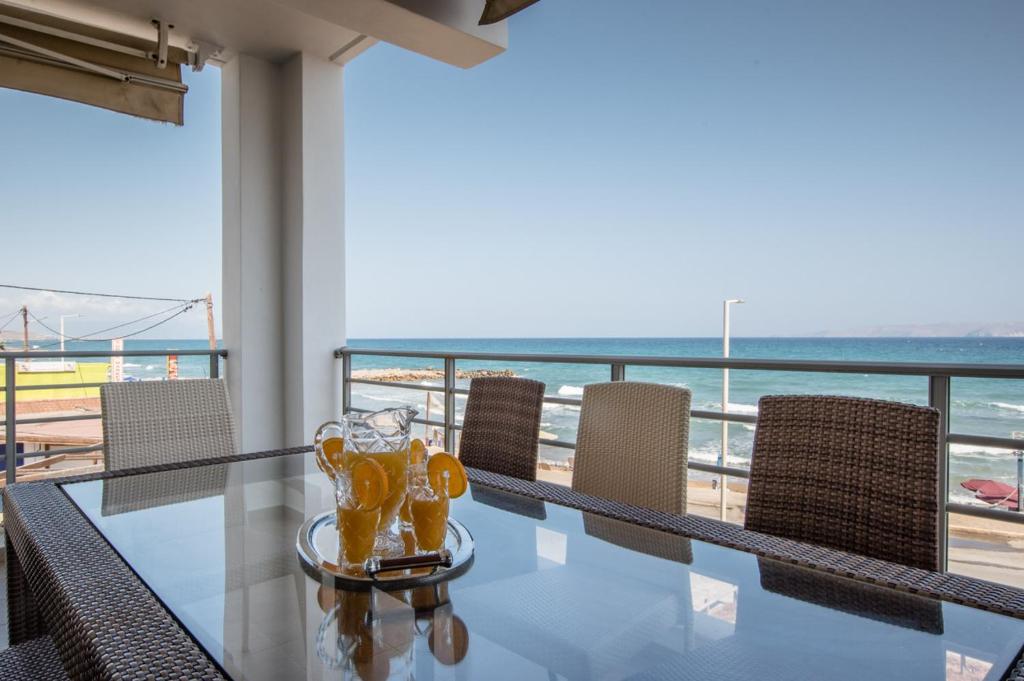 a dining table with chairs and a view of the beach at White Crystal Beachfront Apartment in Gournes