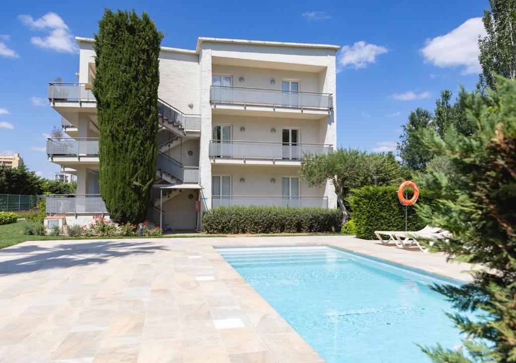 un apartamento con piscina frente a un edificio en Apartaments Terraza - Santa Maria, en Roses