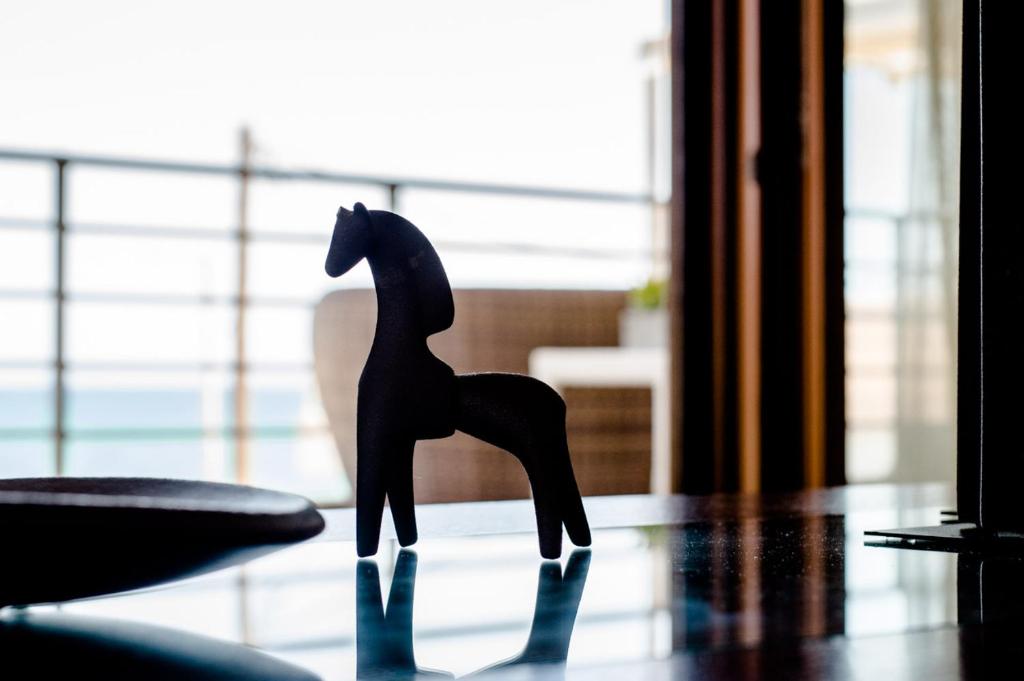 a wooden horse figurine sitting on top of a table at White Crystal Beachfront Apartment in Gournes
