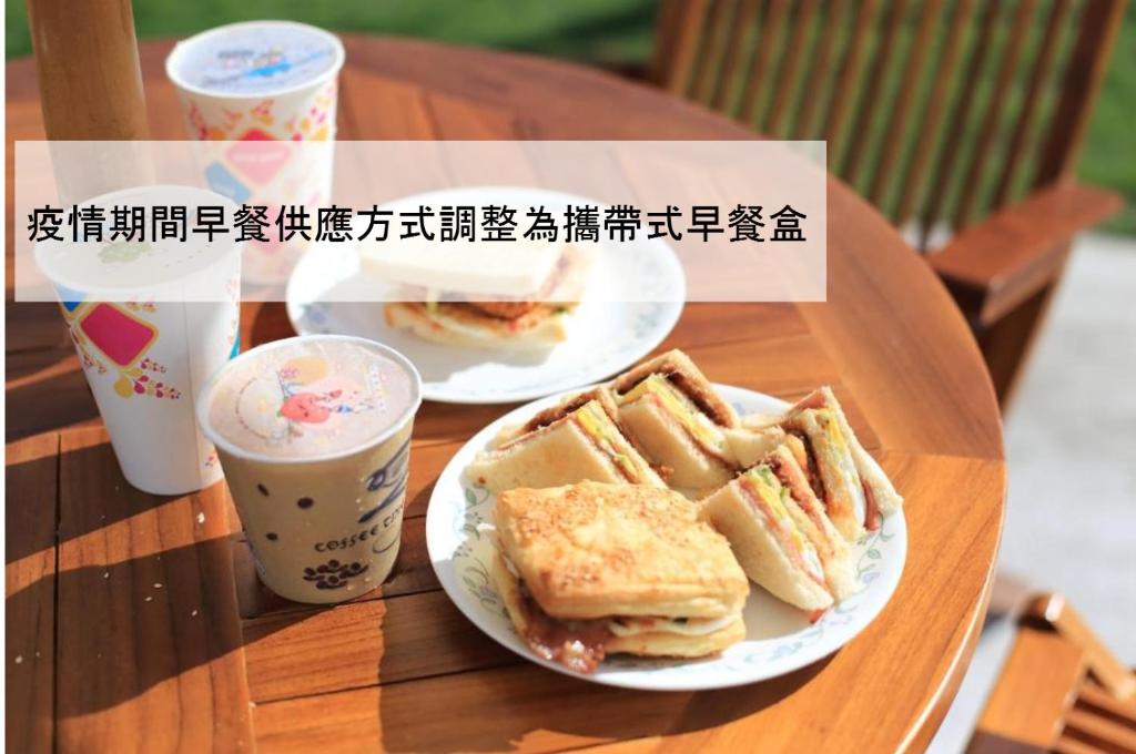 two plates of sandwiches and two cups of coffee on a table at Cai Feng B&amp;B in Ji&#39;an