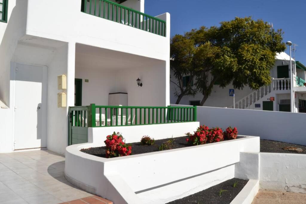 ein weißes Gebäude mit Blumen im Innenhof in der Unterkunft CASA NORI - Apartamento a 4 minutos de la playa in Tías