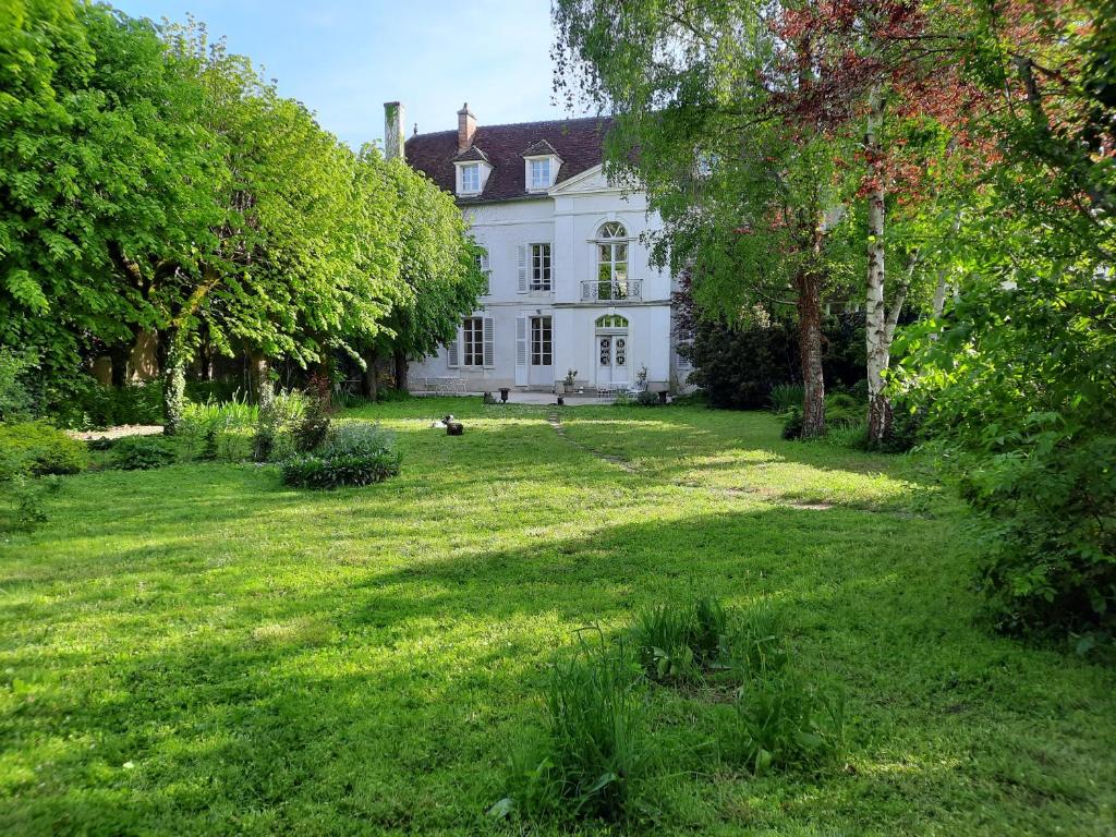 ein großes weißes Haus mit einem großen Hof in der Unterkunft Saint-Eusèbe Mansion - Hôtel Particulier St-Eusèbe in Auxerre