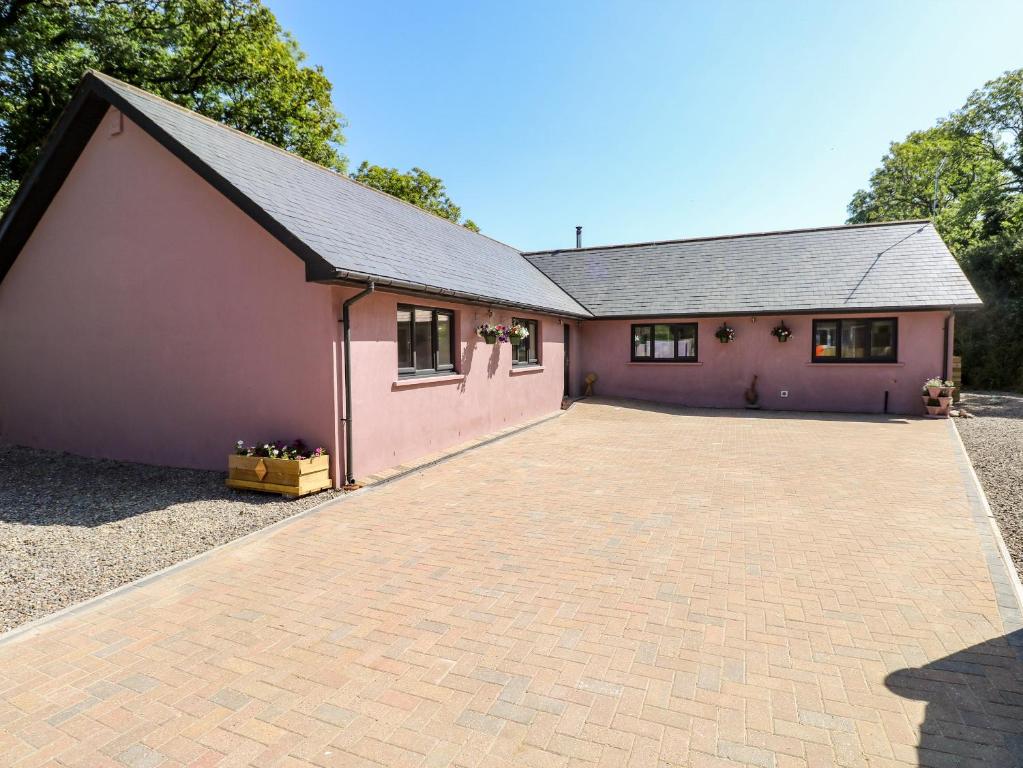 a large pink building with a large driveway at 1 The Warren in Narberth
