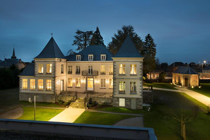 a large house with its lights on at night at Domitys Le Carillon d'or in Maubeuge