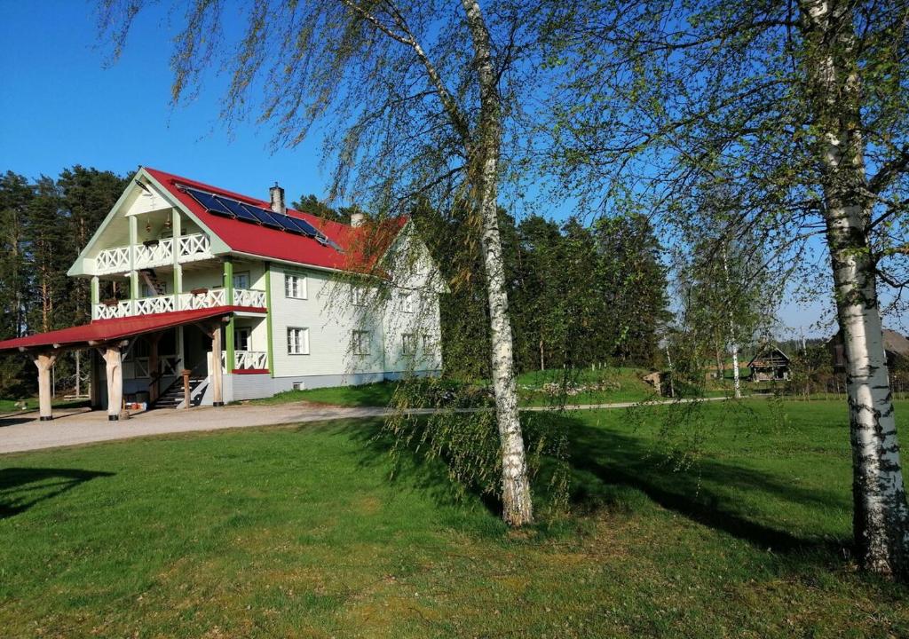 a large white house with a red roof at Mesikamäe puhkemaja in Põlva