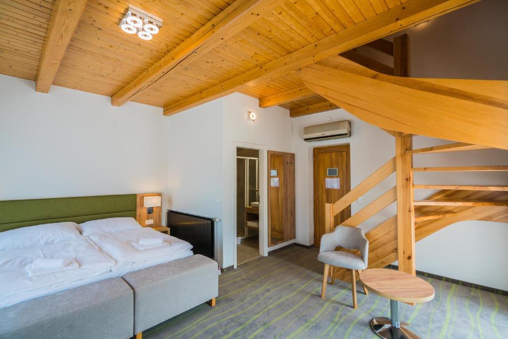 1 dormitorio con 1 cama grande y una escalera en Hotel Diana, en Siófok