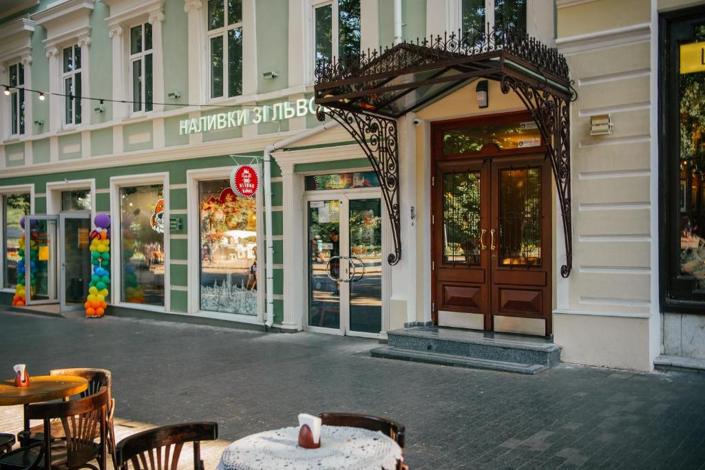 a restaurant with tables and chairs in front of a building at D31 Hotel in Odesa