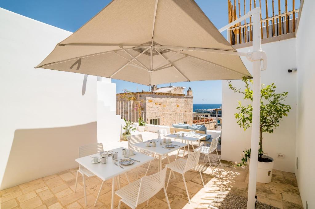 a patio with a table and an umbrella at Tre Archi Suite & Relais in Polignano a Mare
