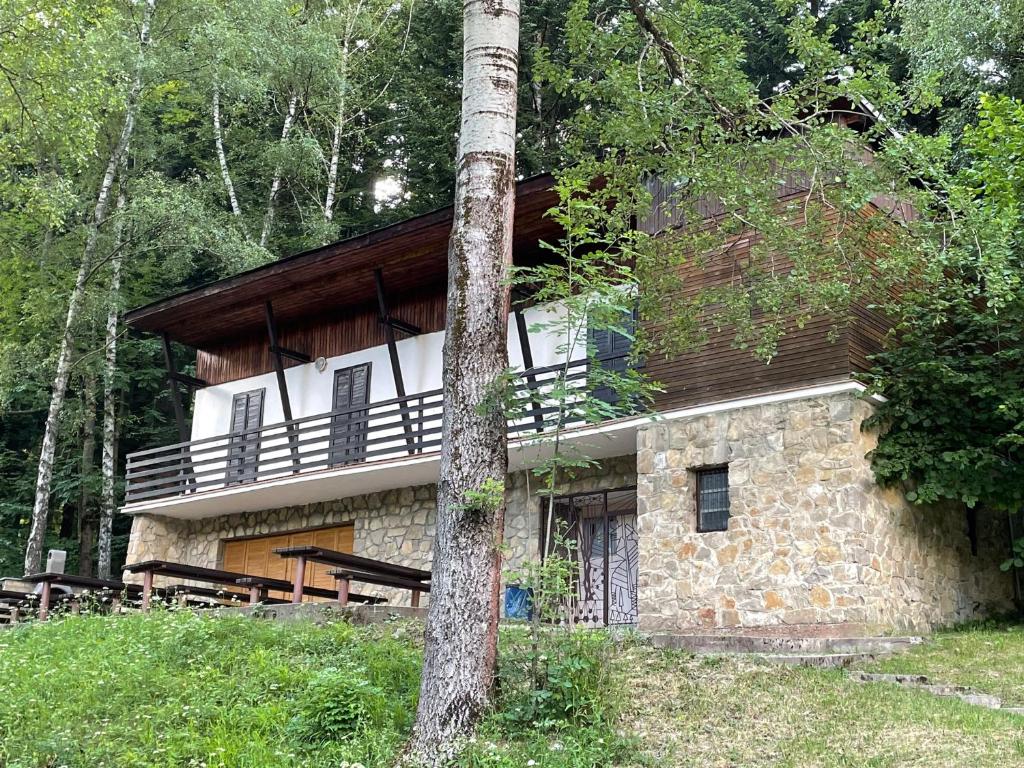 een groot stenen huis met een balkon in het bos bij Chata SOŠS Vrátna Dolina in Terchová