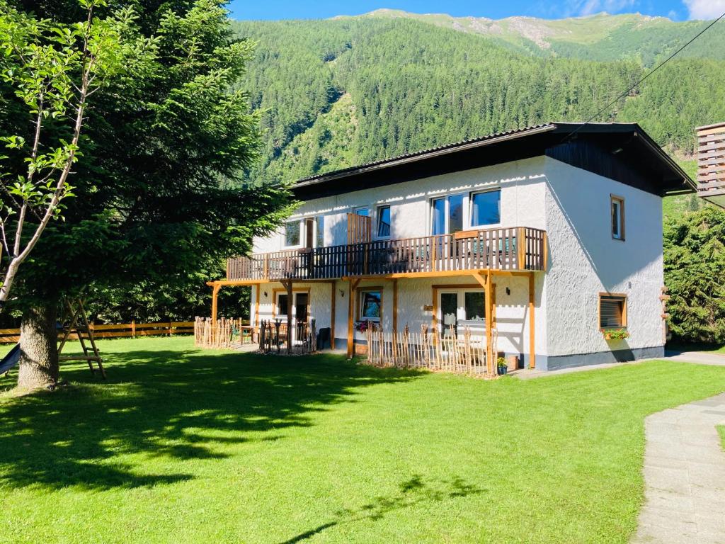 una casa con un gran patio con un árbol en Mallnbach Apartments, en Mallnitz