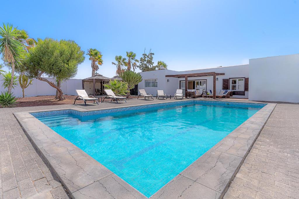 a swimming pool in front of a house at Villa Bella Lanzarote in Costa Teguise
