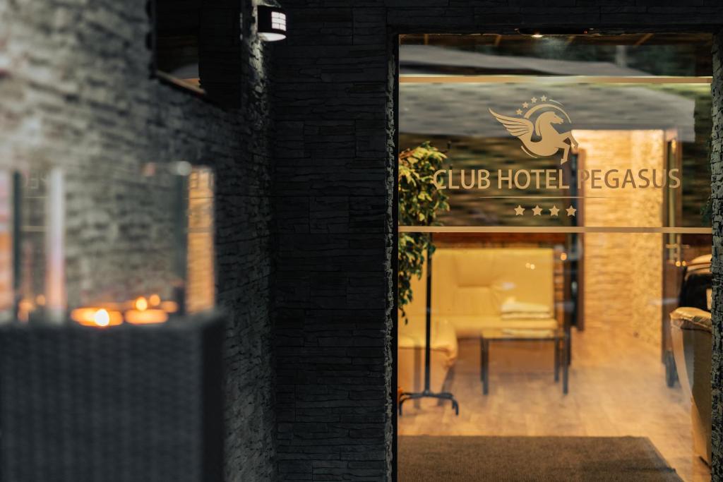 una puerta a un hotel club con una mesa en una ventana en Club Hotel Pegasus, en Tiszaug