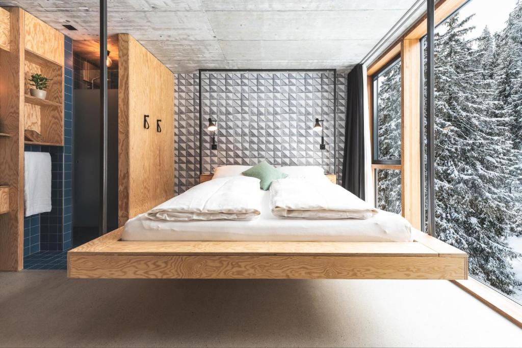 a bed in a room with a window at Riders Hotel in Laax