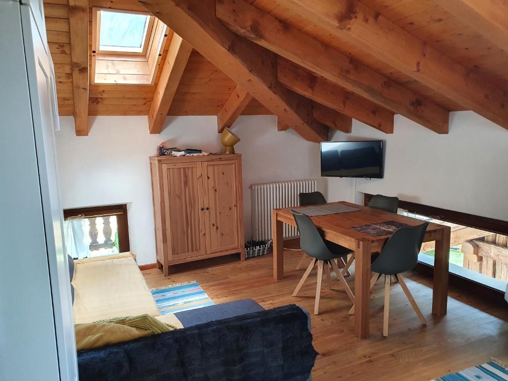 a living room with a wooden table and a tv at Mansarda bilocale centro Brusson in Brusson