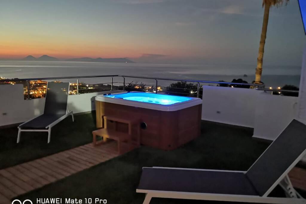 een hot tub op een balkon met uitzicht op de oceaan bij Loft incantevole con idromassaggio esterno privato in Patti