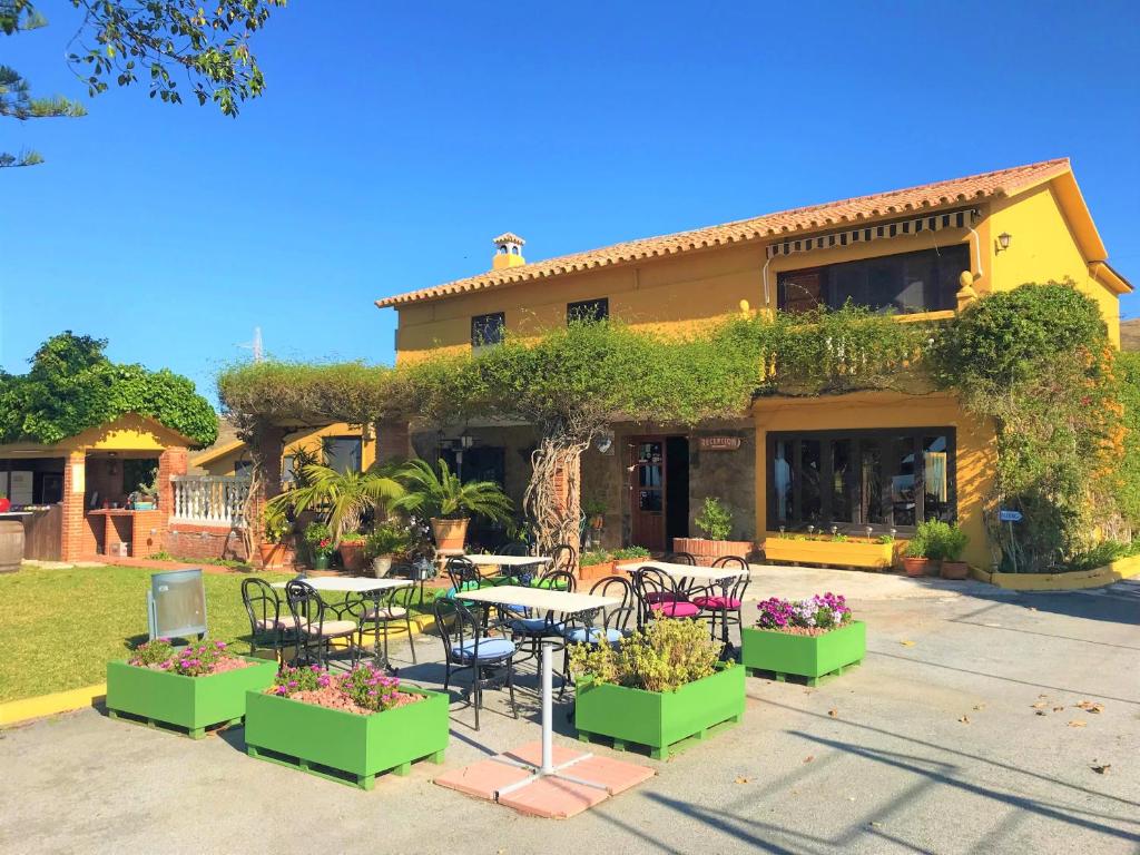 
a patio area with a table, chairs, and patio furniture at Cortijo Amaya in Torrox Costa
