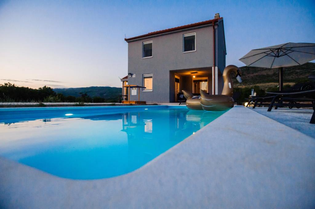 Villa con piscina frente a una casa en Family dream house, en Ružić