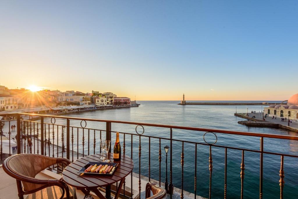 balcón con mesa, sillas y vistas al océano en Belmondo Hotel, en La Canea