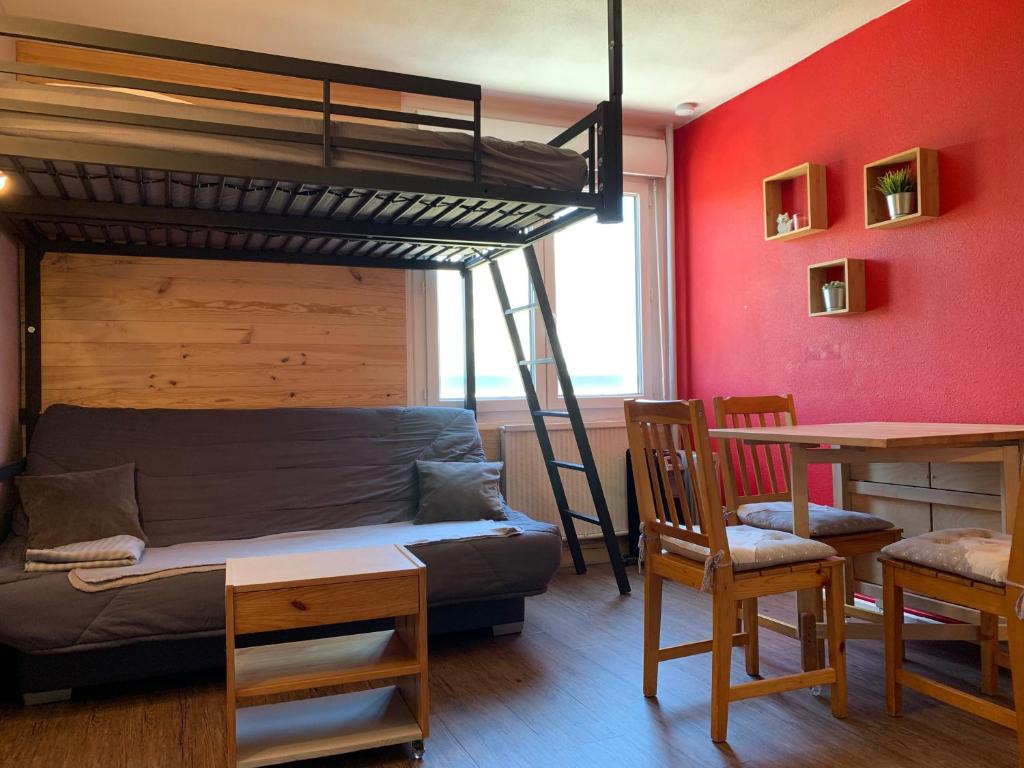 a bedroom with a bunk bed and a desk and a table at Appartement Superdevoluy Le Petit Suisse in Le Dévoluy