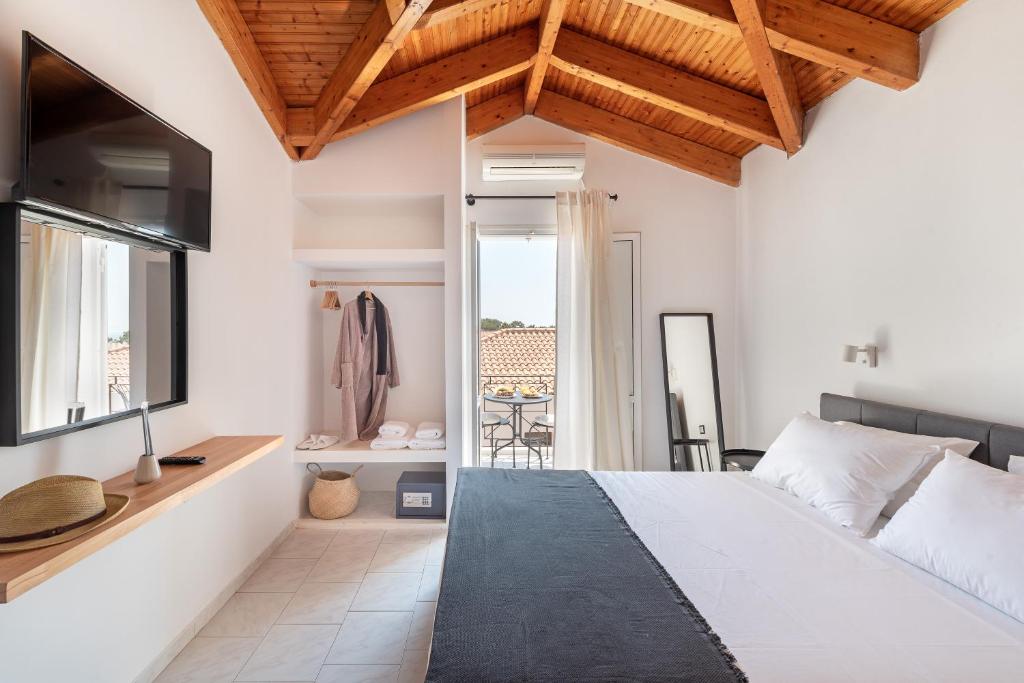 a bedroom with a large bed and a tv at Costa Azzurra Hotel in Skala Kefalonias