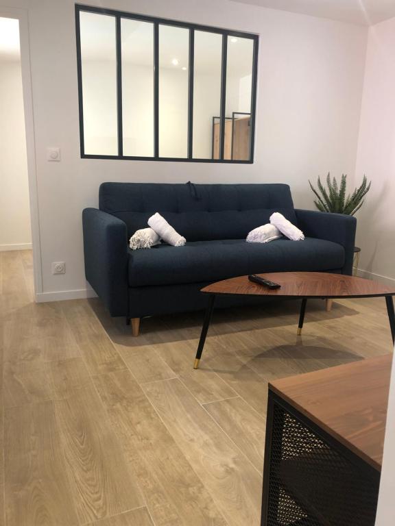 un salon avec un canapé bleu et une table basse dans l'établissement NEW - 2 pièces Vieil Antibes - Marché provençal, à Antibes