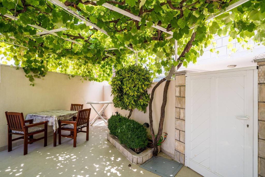 a patio with a table and chairs under a tree at Guest House Vulić in Dubrovnik