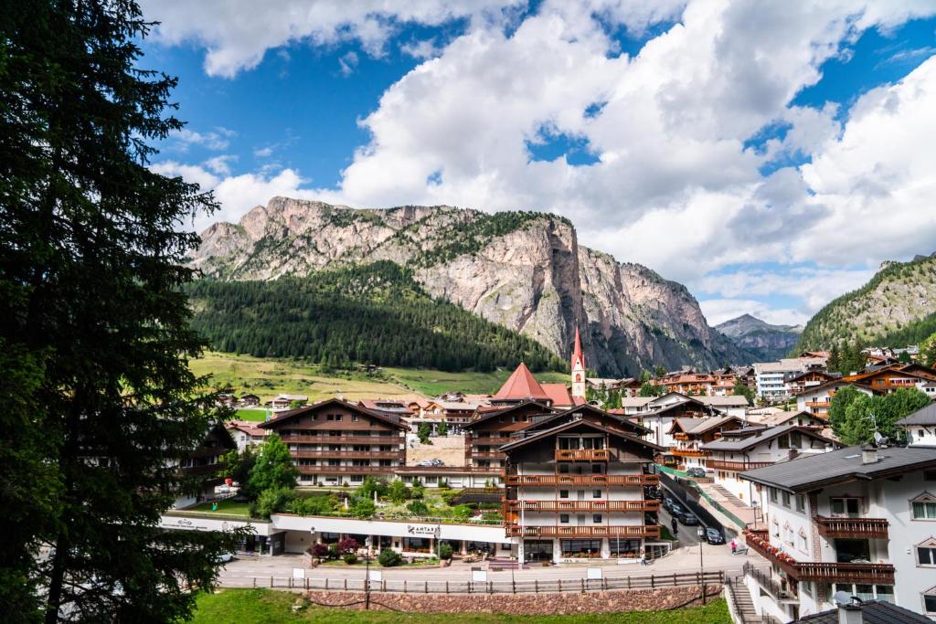 Una vista de una ciudad con montañas al fondo. en Hotel Antares, en Selva di Val Gardena