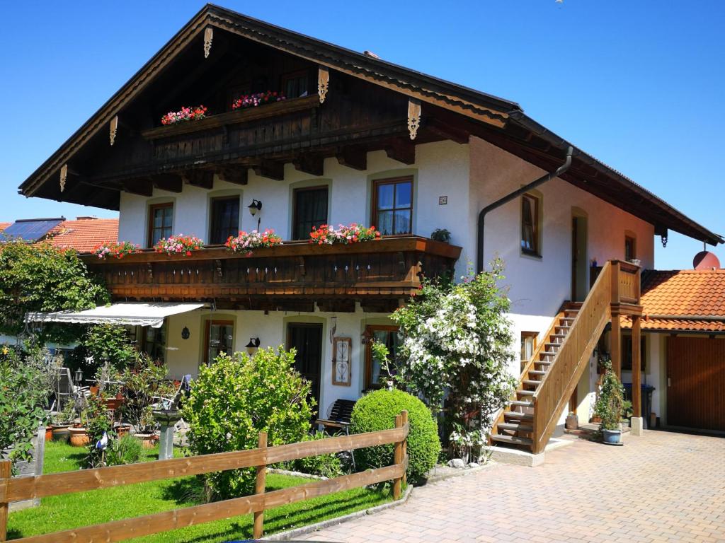ein Haus mit einem Balkon mit Blumen darauf in der Unterkunft Ferienwohnungen Kern in Aschau im Chiemgau