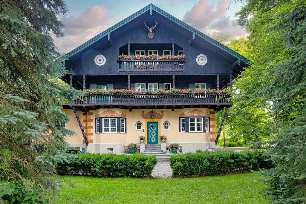 a house with a green door and a balcony at Villa Zollhaus Bed & Breakfast in Türkheim