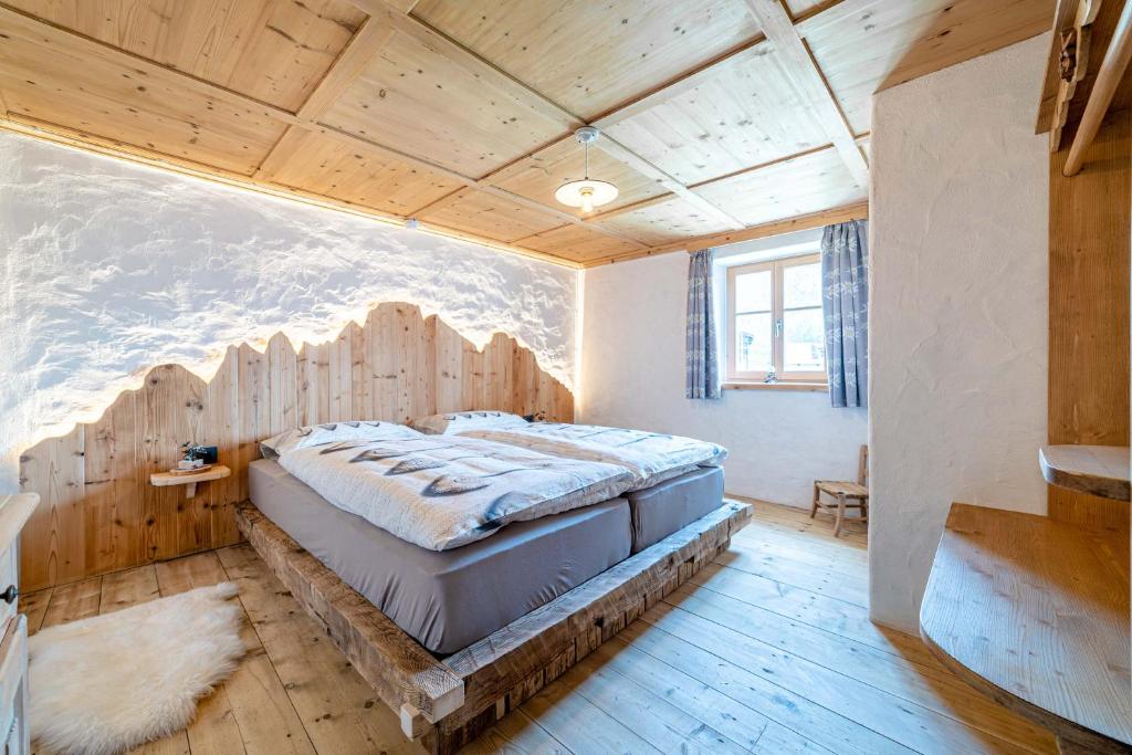 a bedroom with a large bed with a wooden ceiling at Ospitalità Diffusa Laste Dolomites - Cèsa del Bepo Moro in Colle Santa Lucia