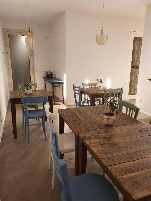 jadalnia z drewnianymi stołami i niebieskimi krzesłami w obiekcie Casa Lunaria B&B w mieście Porto SantʼElpidio