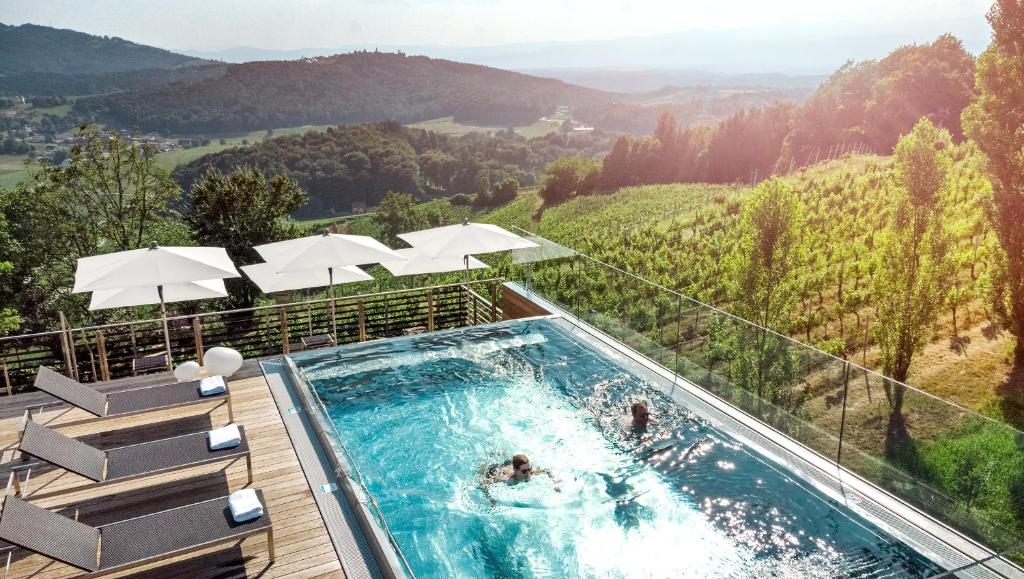 einen Pool mit Bergblick in der Unterkunft Weingartenhotel Harkamp Südsteiermark in Sankt Nikolai im Sausal