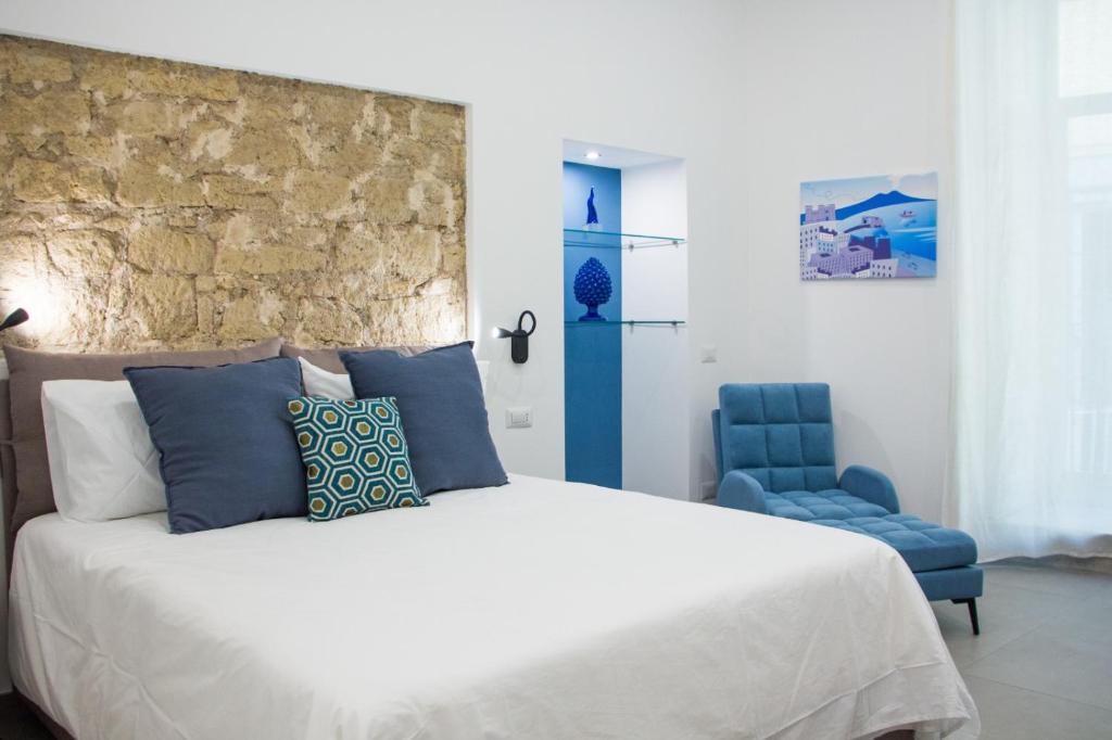 a bedroom with a bed and a blue chair at Blue Plebiscito in Naples