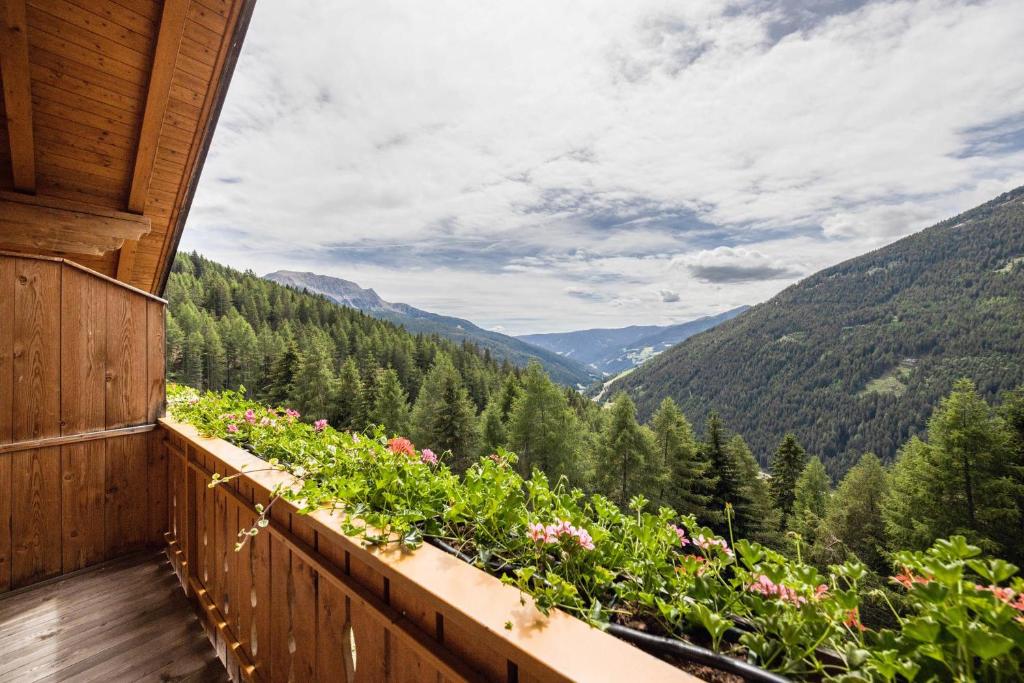 a balcony with flowers and a view of mountains at Wieserhof Ferienwohnung Priml in Sarntal