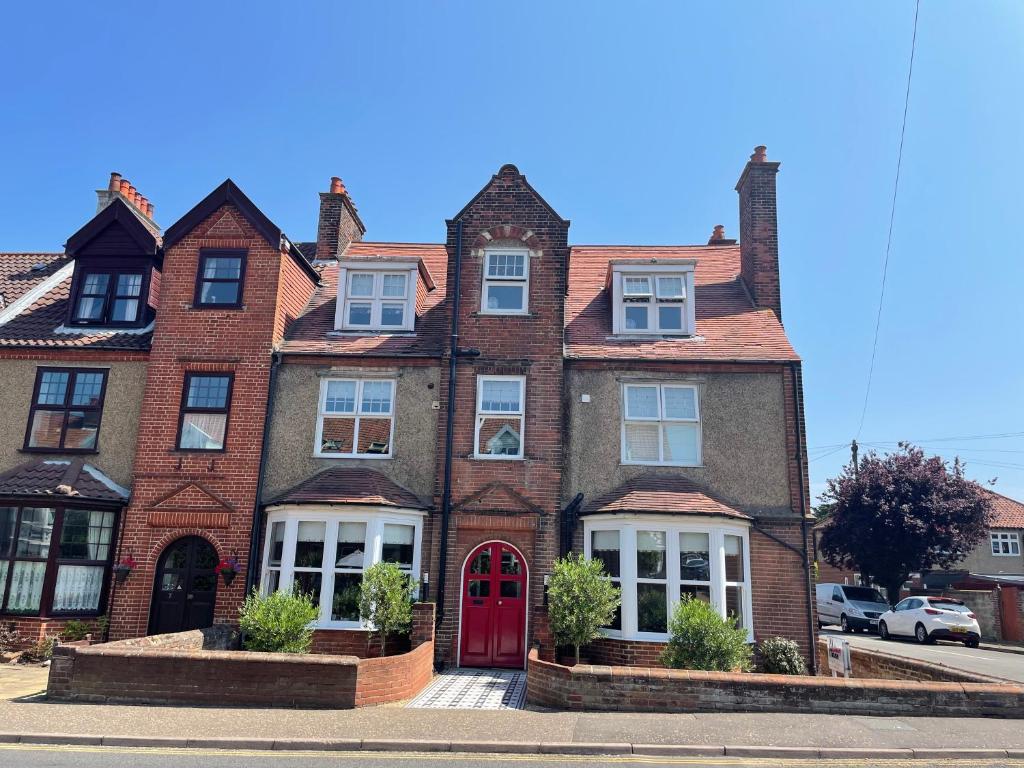 una gran casa de ladrillo con puerta roja en Holway House en Sheringham