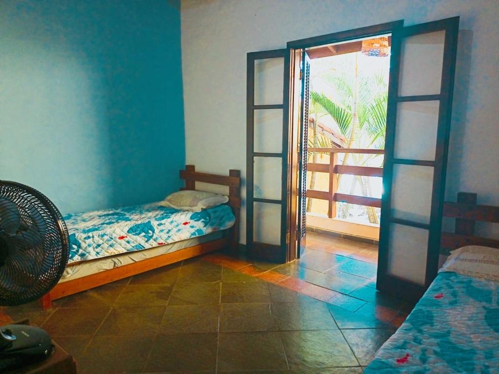 a bedroom with a bed and an open door at Sobrado Estiloso in Caraguatatuba