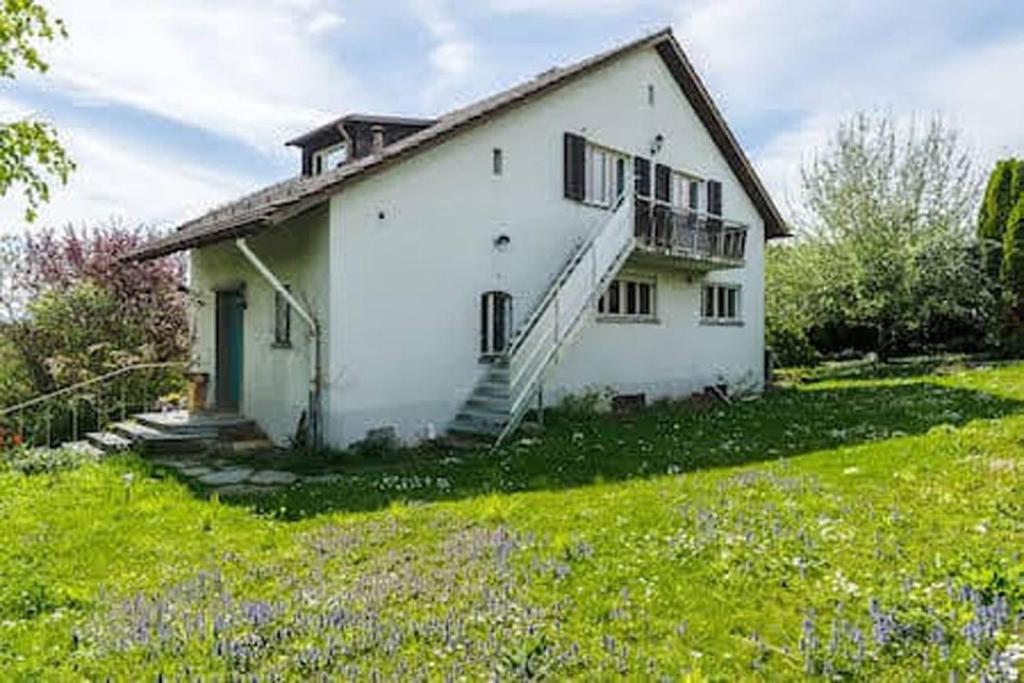 a white house with a staircase in a yard at Zurich Airport Apartment Loft 45m2 free Parking, Airport Drive Service, separate Kitchen in Kloten