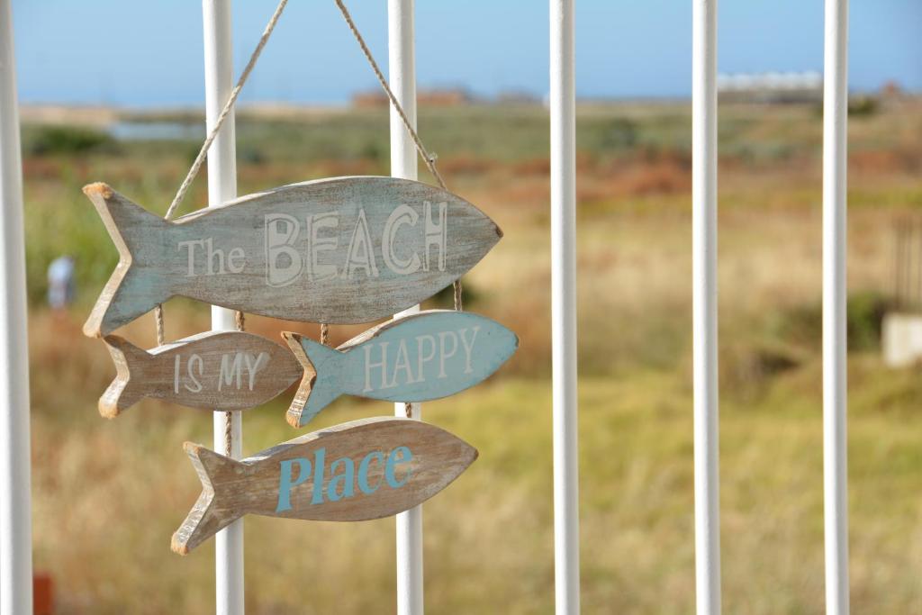 Ein Schild, auf dem steht, dass der Strand mein glücklicher Ort ist. in der Unterkunft Praia Dria in Armação de Pêra