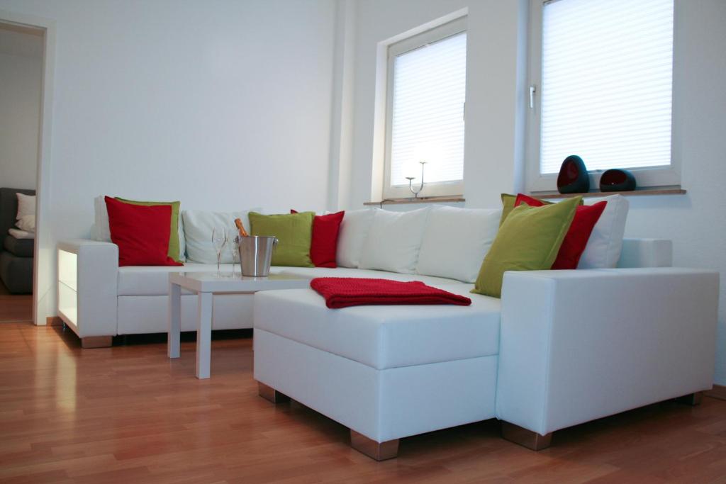 Premium Ferienwohnung Sonnenaufgang في فِتْسِنهاوزن: غرفة معيشة مع كنبتين بيضاء وطاولة