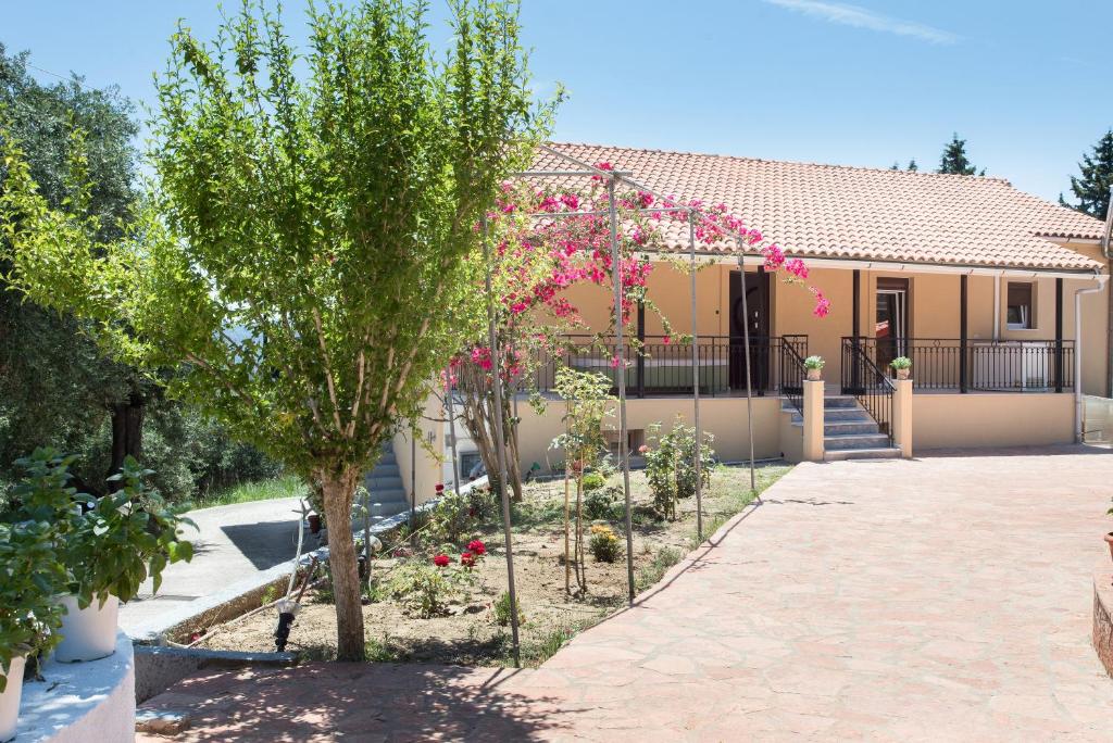 een tuin voor een huis met bomen en bloemen bij Olive Tree House in Evropoúloi