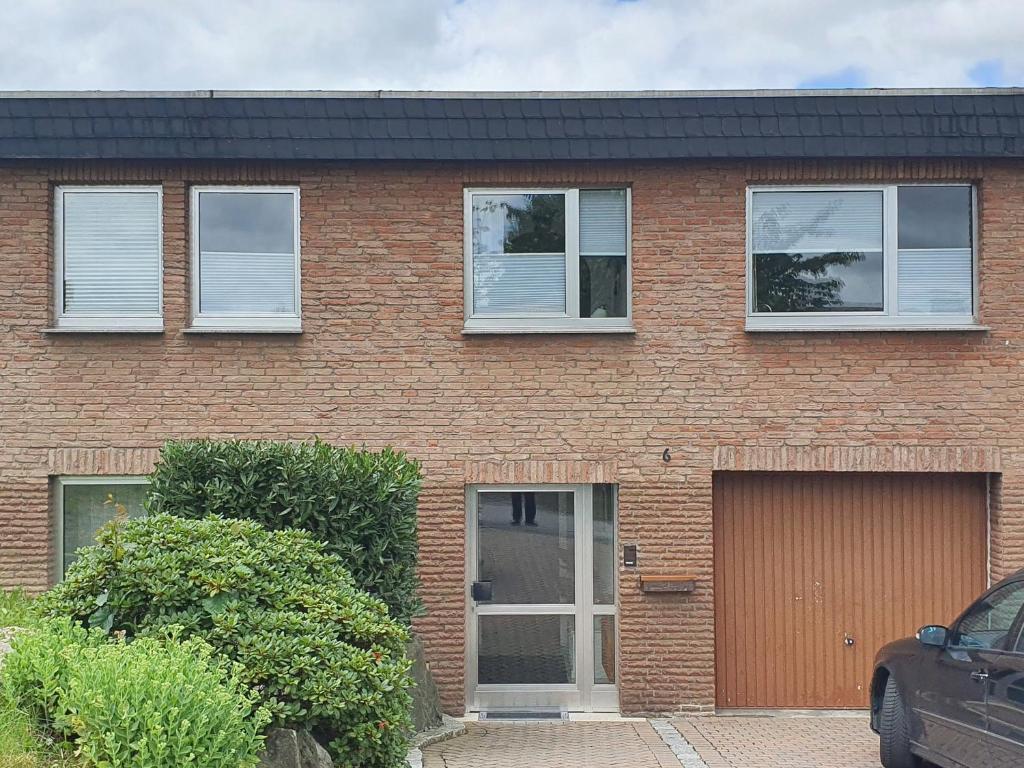 een stenen huis met drie ramen en een garage bij Ferienwohnungen am Finkenweg in Bestwig