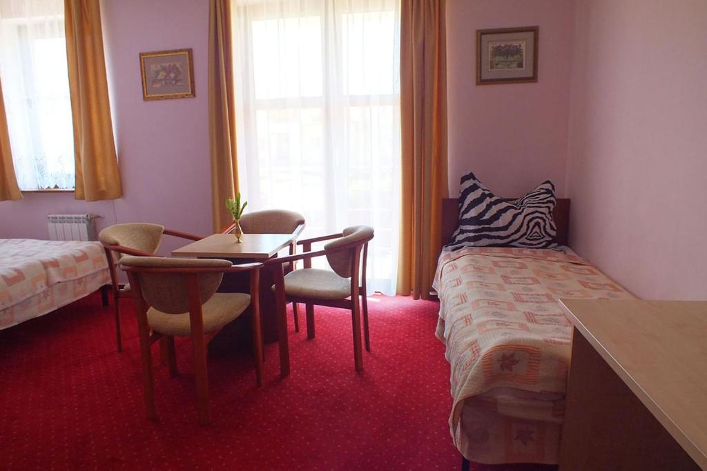 Łóżko lub łóżka w pokoju w obiekcie Hotel Aleksander