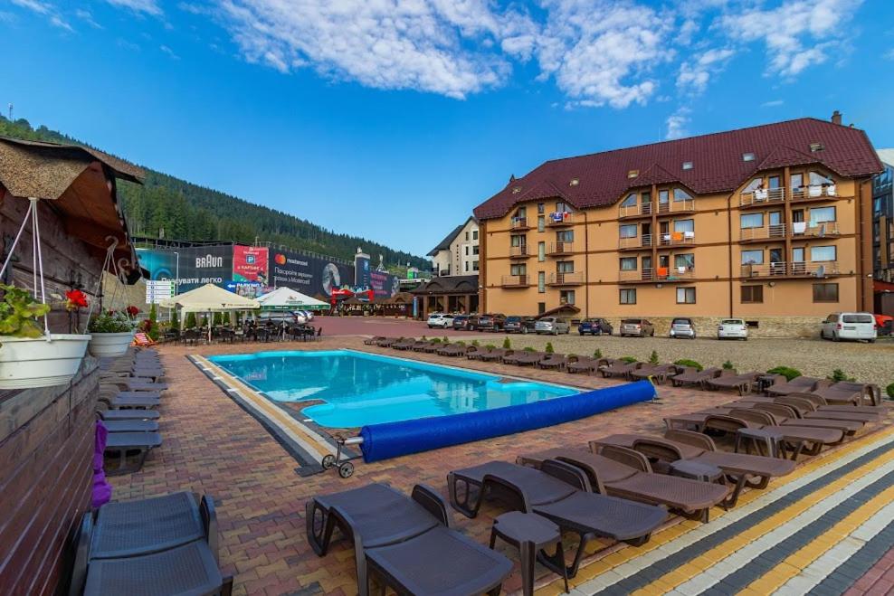 a resort with a swimming pool and lounge chairs at Villa Victoria in Bukovel