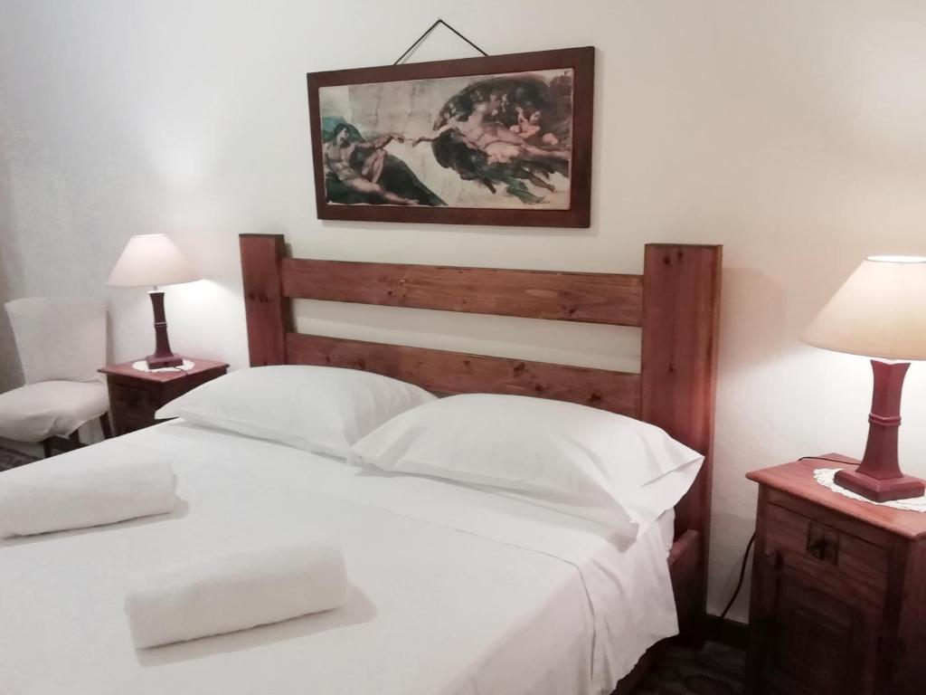 een slaapkamer met een groot wit bed met 2 lampen bij Maride Holiday in Noto