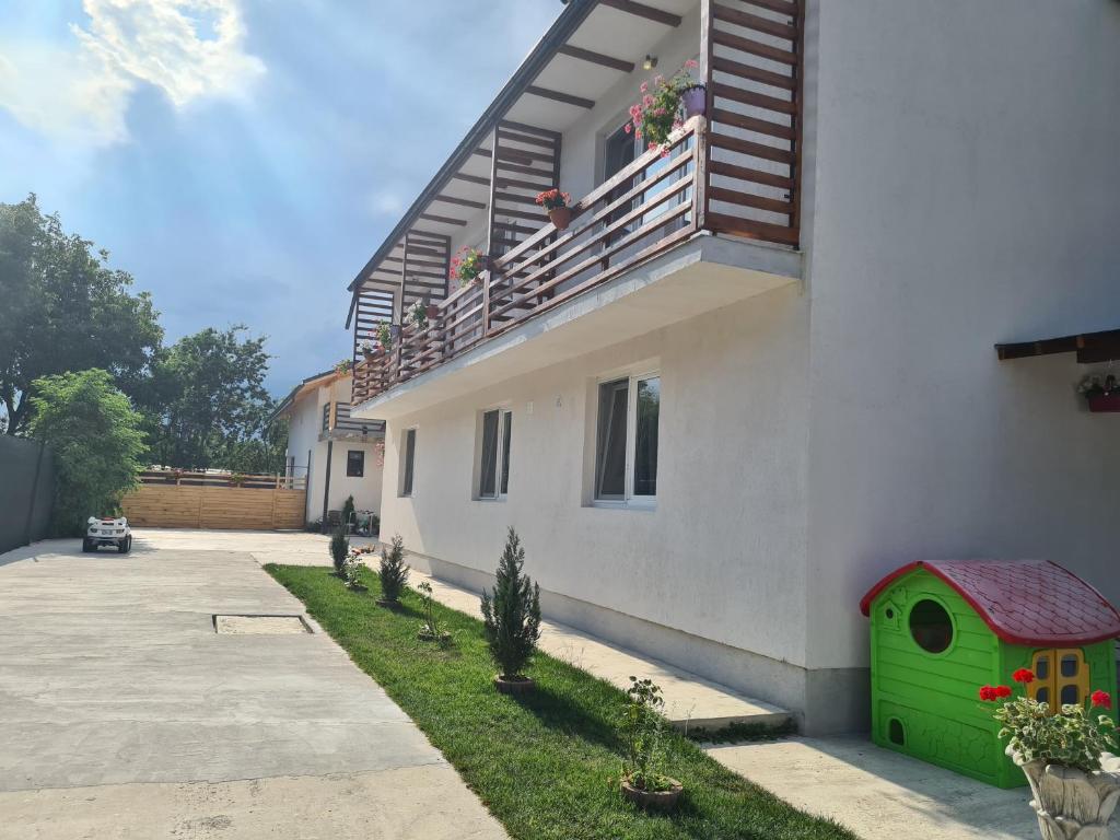 una casa con una casa de perros verdes a un lado en Luca's studio 3 ,Close to Therme Bucharest, Airport Otopeni en Baloteşti