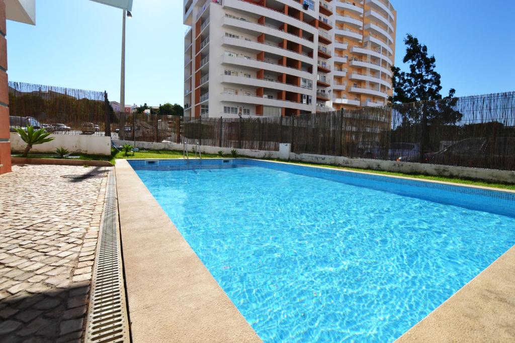 uma grande piscina azul ao lado de um edifício alto em Top Refuge by ALgest em Portimão